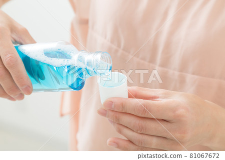 A woman's hand pouring mouthwash 81067672