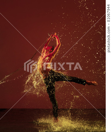 Passion, emotion. One young male ballet dancer in motion, action under the rain over red background in neon light. Passion, emotion. One young male ballet dancer in motion, action under the rain over red background in neon light. 81067944