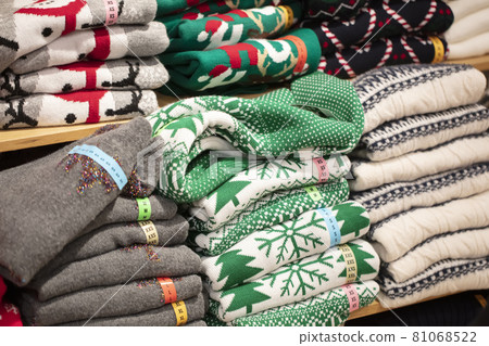 Sweaters with Christmas ornaments in the store.Stack of folded knitted 81068522