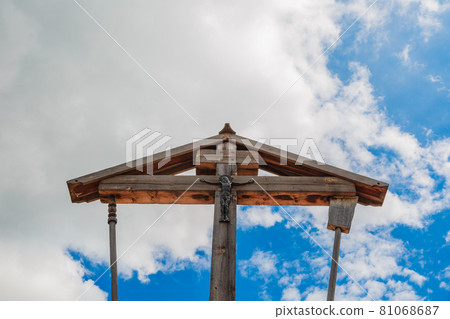 Wooden crucifixion of Jesus Christ on a background of blue sky with clouds. Wooden crucifixion of Jesus Christ on a background of blue sky with clouds. 81068687