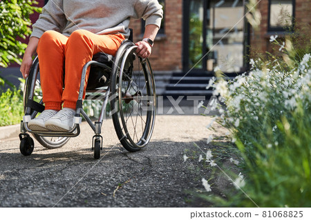 Female person with loss of leg function sitting at the special armchair Female person with loss of leg function sitting at the special armchair 81068825