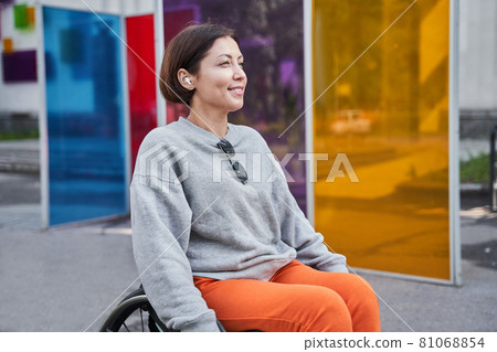 Girl with lower body disability looking away and smiling while enjoying of the summer 81068854