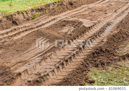 Traces and patterns from tire tread wheels on the ground of industrial transport on the construction site Traces and patterns from tire tread wheels on the ground of industrial transport on the construction site 81069031