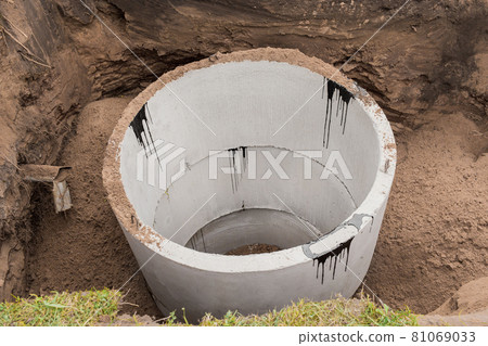 Concrete sewer rings in the ground. Construction or repair of sewerage on an industrial site Concrete sewer rings in the ground. Construction or repair of sewerage on an industrial site 81069033