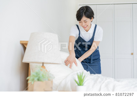 Young woman doing bed making Young woman doing bed making 81072297