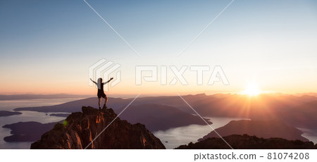 Adventurous Caucasian Woman Hiking on top of a Rocky Mountain Cliff. 81074208