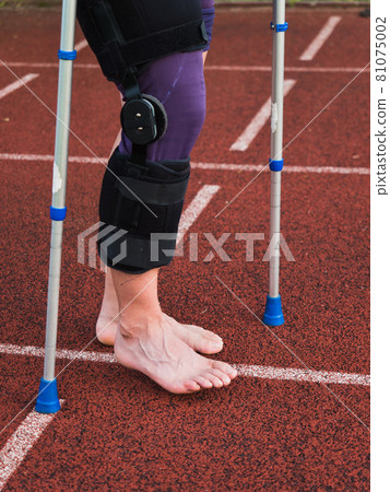 Hurt runner walk by crutches on track after competition Hurt runner walk by crutches on track after competition 81075002