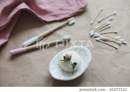 Eco spa friendly products. Handmade natural soap, wooden toothbrushes, cotton swabs and hairbrush on craft paper background top view with copyspace 81075552