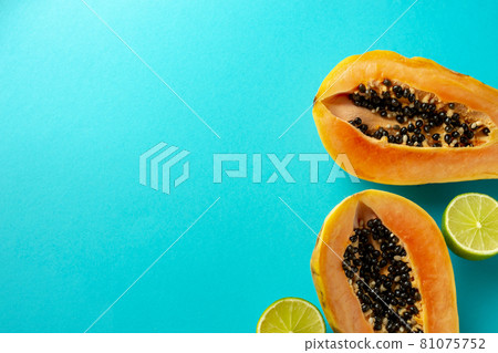 Summer composition. Tropical lime and papaya fruit cut in half lie on a blue background. Summer concept. Flat lay, top view, copy space 81075752