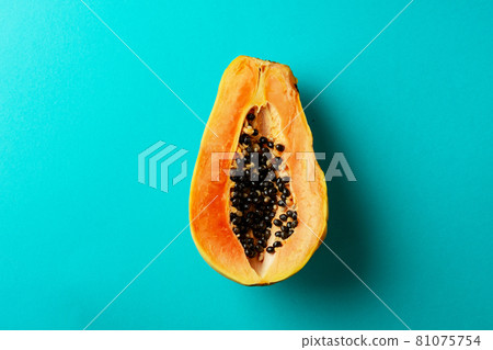 Summer composition. Tropical papaya fruits cut in half lie on a blue background. Summer concept. Flat lay, top view, copy space Summer composition. Tropical papaya fruits cut in half lie on a blue background. Summer concept. Flat lay, top view, copy space 81075754