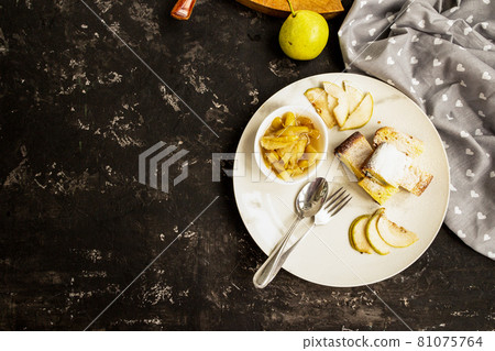 Pear jam and pie are on a white plate. Black background. Copy space. Sweet breakfast and snack. Pear jam and pie are on a white plate. Black background. Copy space. Sweet breakfast and snack. 81075764