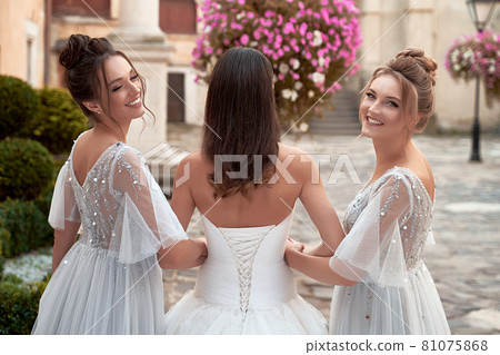 Beautiful bride and bridesmaids. Wedding day in old beautiful European city. Beautiful bride and bridesmaids. Wedding day in old beautiful European city. 81075868