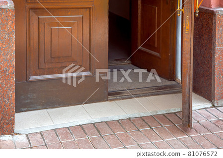 open wooden entrance doors with foot mat close-up of building architecture, nobody. 81076572