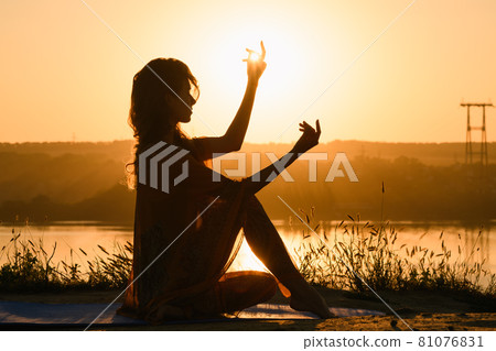 Beautiful girl silhouette in warm sunrise light 81076831