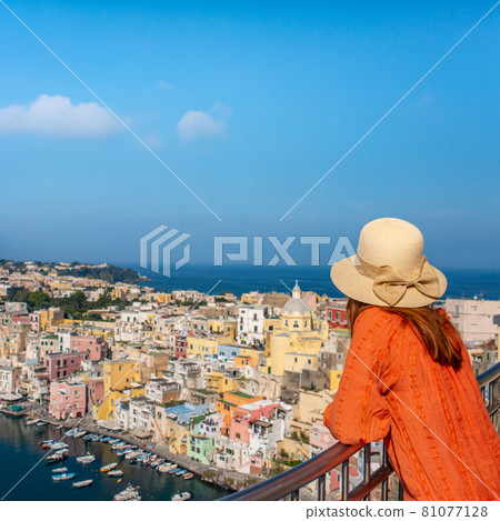 Beautiful young girl over panoramic view of Procida Island, Naples, Italy. 81077128