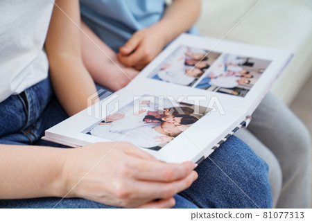 top view. mother and daughter watch photobook from discharge of newborn baby 81077313