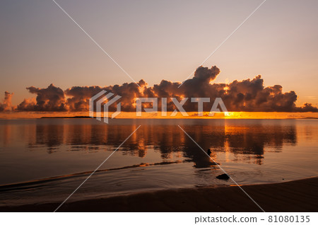 Gorgeous sunrise with amazing huge clouds reflecting on smooth sea like a mirror. Iriomote Island. Gorgeous sunrise with amazing huge clouds reflecting on smooth sea like a mirror. Iriomote Island. 81080135