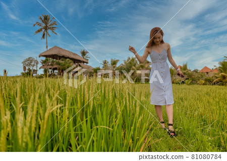 A woman taking a walk in the countryside of Ubud, Bali 81080784