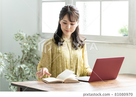 一個用電腦和書學習的女人 81080970