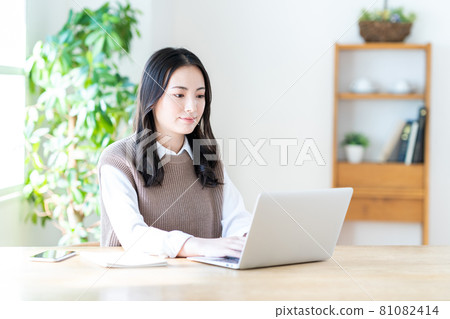 A young woman doing telework in the living room. 81082414