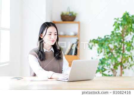 A young woman doing telework in the living room. 81082416
