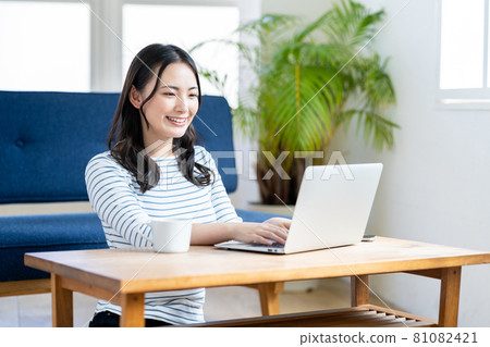 A young woman doing telework in the living room. 81082421