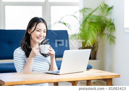 A young woman doing telework in the living room. 81082423