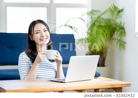 A young woman doing telework in the living room. A young woman doing telework in the living room. 81082432