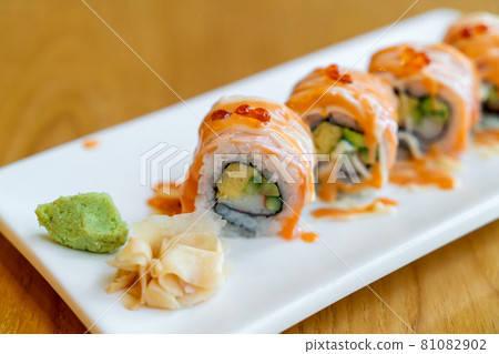 salmon roll sushi with sauce on top 81082902