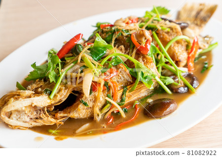 deep fried sea bass fish with sweet sauce and trimmings deep fried sea bass fish with sweet sauce and trimmings 81082922