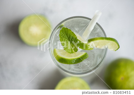 Summer drink juicy lime slice top view, Exotic summer drinks refreshing of cold drinks glasses fresh fruit on ice homemade cocktail tea with mojito lemon lime and mint leaf 81083451
