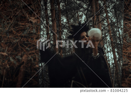 blurry mystical reflection of a black witch with a skull in her hands performing a satanic ritual blurry mystical reflection of a black witch with a skull in her hands performing a satanic ritual 81084225