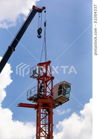 Setting up a tower crane in the construction site 81084337