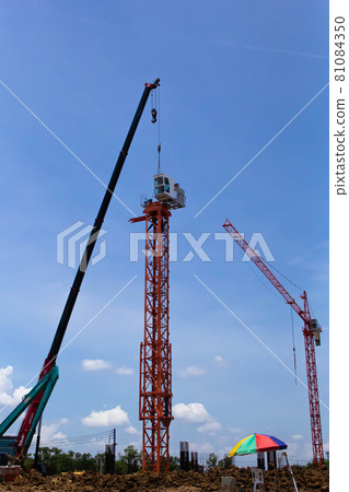 Setting up a tower crane in the construction site 81084350