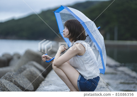 Woman in the sea on a rainy day Woman in the sea on a rainy day 81086356