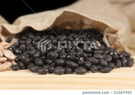 Burlap Bag of Dried Black Beans Spilled on Wooden Table Burlap Bag of Dried Black Beans Spilled on Wooden Table 81087493