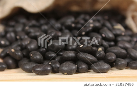 Burlap Bag of Dried Black Beans Spilled on Wooden Table Burlap Bag of Dried Black Beans Spilled on Wooden Table 81087496