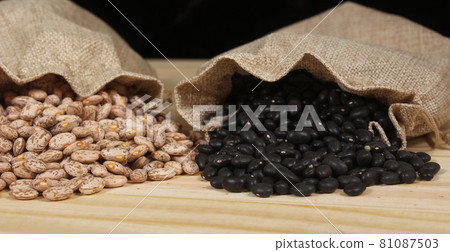 Dried Pinto Beans and Black Beans in Burlap Bag on Wooden Background 81087503