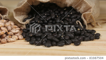 Dried Pinto Beans and Black Beans in Burlap Bag on Wooden Background 81087504
