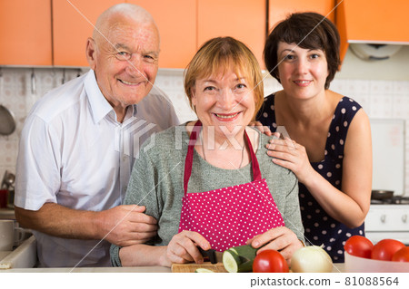 Senior couple and their daughter cooking 81088564
