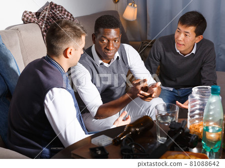 Friendly meeting in men company on couch at home Friendly meeting in men company on couch at home 81088642