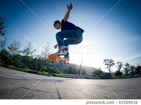 Asian woman skateboarder skateboarding in sunrise city Asian woman skateboarder skateboarding in sunrise city 81089016