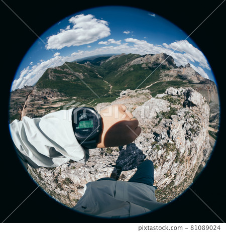 Hiker on high altitude mountain top checking the altimeter on the sports watch 81089024
