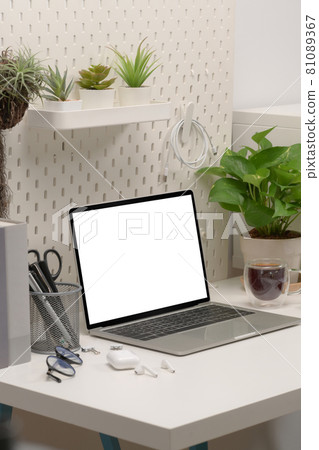 Comfortable workplace with laptop computer and houseplant. Comfortable workplace with laptop computer and houseplant. 81089367