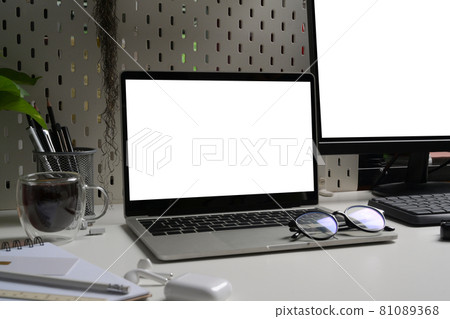 Computer laptop with blank screen and glasses on white office desk. Computer laptop with blank screen and glasses on white office desk. 81089368