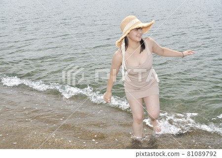 Taking a portrait of a woman in a mini one-piece in a straw hat on the coast of Esashi-cho, Hokkaido in midsummer Taking a portrait of a woman in a mini one-piece in a straw hat on the coast of Esashi-cho, Hokkaido in midsummer 81089792