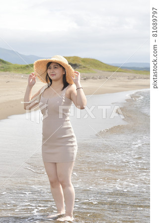 Taking a portrait of a woman in a mini one-piece in a straw hat on the coast of Esashi-cho, Hokkaido in midsummer Taking a portrait of a woman in a mini one-piece in a straw hat on the coast of Esashi-cho, Hokkaido in midsummer 81089797