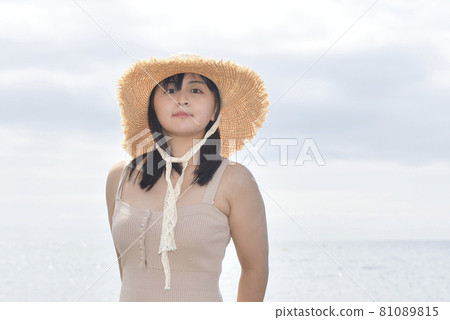 盛夏時節，在北海道江差町海岸拍攝身著迷你連體衣戴草帽的女性肖像 81089815