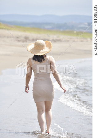 Taking a portrait of a woman in a mini one-piece in a straw hat on the coast of Esashi-cho, Hokkaido in midsummer 81089835
