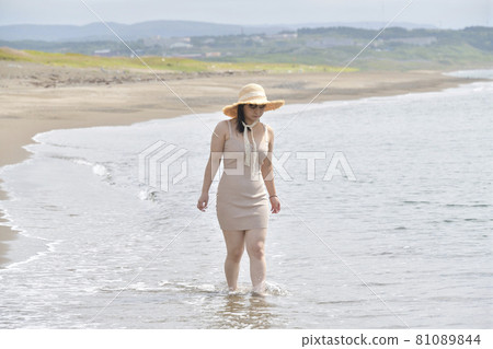 Taking a portrait of a woman in a mini one-piece in a straw hat on the coast of Esashi-cho, Hokkaido in midsummer Taking a portrait of a woman in a mini one-piece in a straw hat on the coast of Esashi-cho, Hokkaido in midsummer 81089844